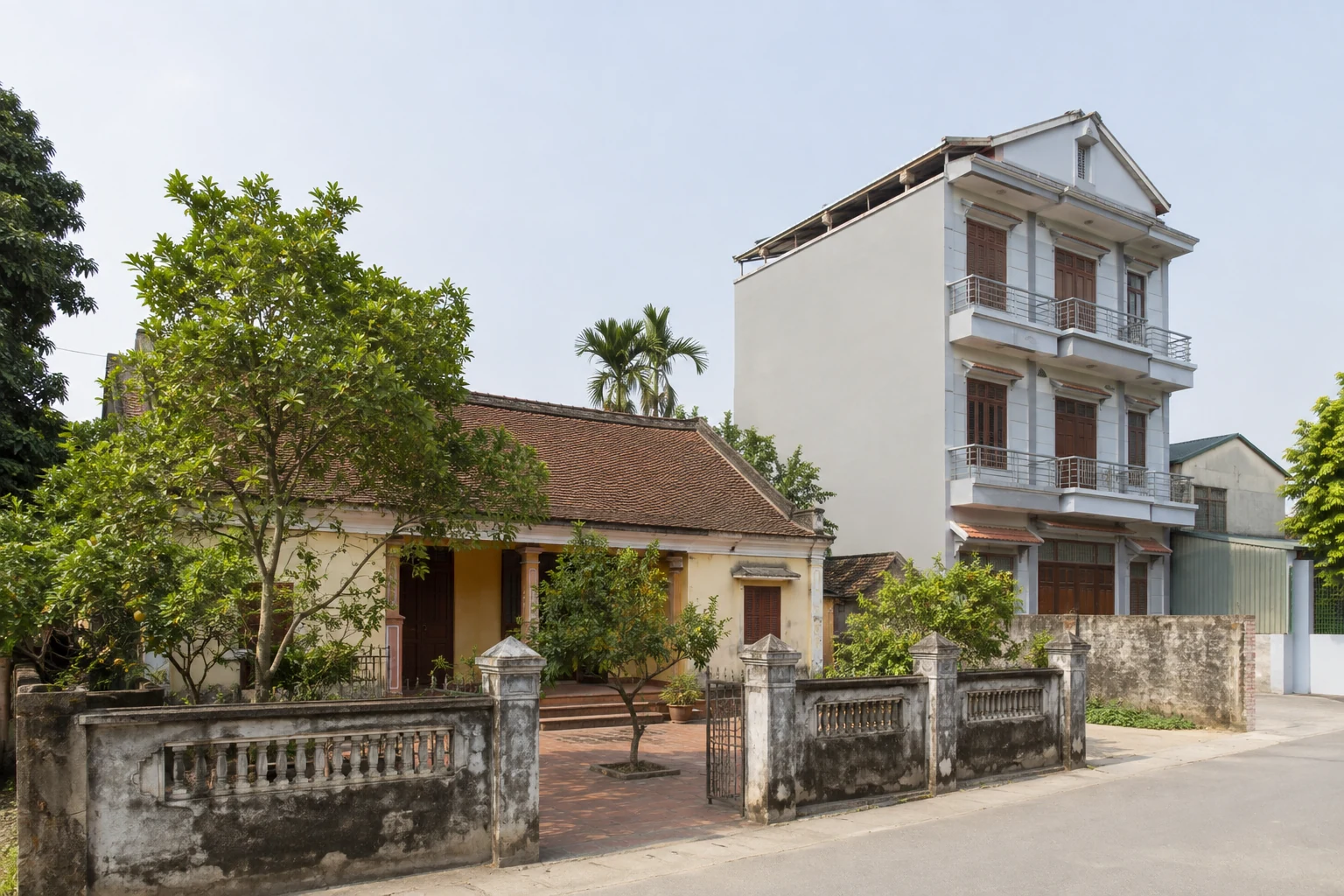 Älteres Familienhaus mit Innenhof neben einem schmalen Stadthaus in Hoài Đức